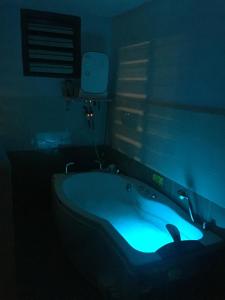 Habitación oscura con baño con bañera azul. en Ipoh homestay, en Ipoh