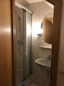 a bathroom with a shower and a sink and a mirror at Hotel zur Post limburg Bad camberg in Hünfelden