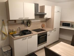 a small kitchen with white cabinets and a sink at The Place in Ljubljana