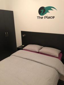 una camera da letto con un letto con l'insegna a muro di The Place a Lubiana