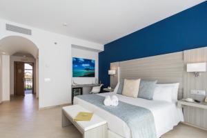 a bedroom with a large bed with a blue wall at Royal Palm Resort & Spa - Adults Only in Playa Jandia
