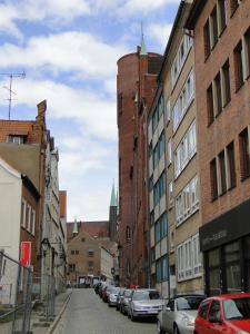 eine Stadtstraße mit parkenden Autos und Gebäuden in der Unterkunft Andrea in Lübeck