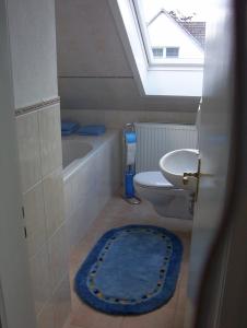 baño con aseo y lavabo y ventana en Ferienwohnung-Osten, en Schenefeld