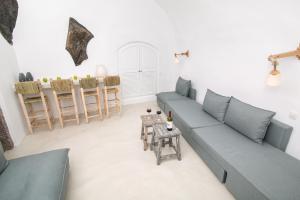 a living room with a blue couch and a table at Opsis Cave House in Oia