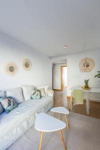 sala de estar con sofá blanco y mesa en Horoko Apartments by gaiarooms en Madrid