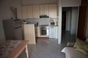 una pequeña cocina con electrodomésticos blancos y una mesa en Apartments Garac, en Dugi Rat