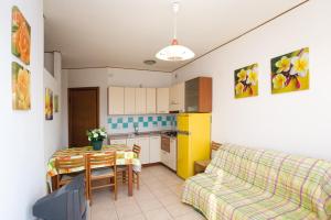 a kitchen with a table and a couch in a room at Linz in Bibione