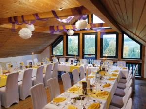 um salão de banquetes com mesas brancas e cadeiras brancas em Landhotel Berggaststätte Bickenriede em Anrode