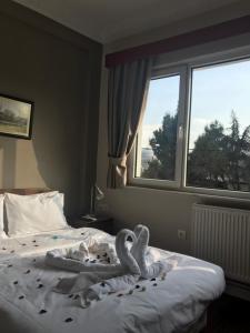 a bed with a white blanket and pillows in front of a window at Hotel Sultanahmet in Istanbul
