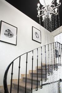 un escalier avec un lustre et un mur blanc dans l'établissement My Pad Provence 4, à Avignon