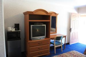 a hotel room with a desk and a tv in a bedroom at Mother Lode Motel in Placerville