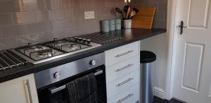 cocina con fogones y encimera en Maplewell House en Leicester