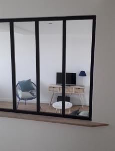 - un miroir dans une chambre avec un bureau et une chaise dans l'établissement Appartement au coeur de Bayonne sur les remparts, à Bayonne