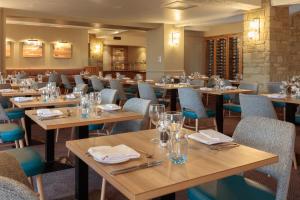 comedor con mesas y sillas de madera en Oxford Witney Hotel, en Witney