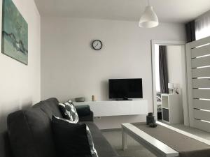 a living room with a couch and a tv at Apartament koloru morza - Turkus in Łeba