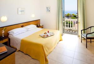 una camera d'albergo con un letto e un vassoio di cibo sopra di Hotel Lamberti ad Alassio