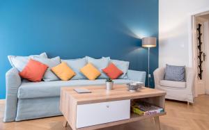 a living room with a blue couch with colorful pillows at DARSISS 2 - Museum Apartment in Athens