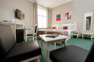 Leone Aparthotel في كراكوف: غرفة فندقية بسريرين وطاولة