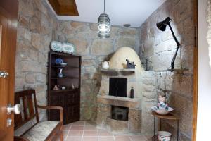 Cette chambre est dotée d'un mur en pierre et d'une cheminée. dans l'établissement Cerrado dos Outeirinhos, à Cinfães