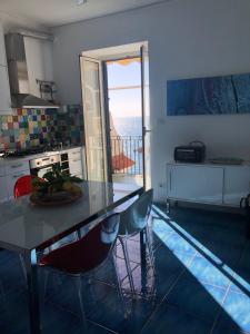 a kitchen with a table and a view of the ocean at Casa La Voce del Mare in Amalfi