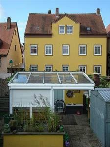 una gran casa amarilla con techo de cristal en Ferienwohnung Baierl en Nördlingen