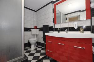 a bathroom with a red sink and a toilet at Apartment Toya in Slatine +39 photos