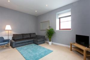 uma sala de estar com um sofá e uma televisão em Granary Suite No3 - Donnini Apartments em Ayr