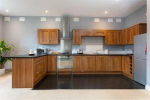 uma cozinha com armários de madeira e um fogão em Granary Suite No3 - Donnini Apartments em Ayr