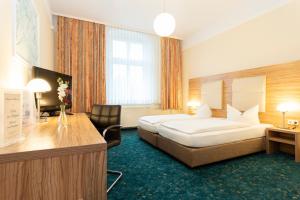 a hotel room with a bed and a desk at Palais am Kleistpark in Frankfurt Oder