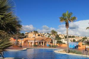 una piscina con palmeras y casas en Montecala, en Benitachell