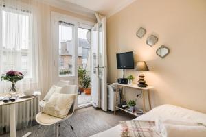 Cette chambre comprend un lit, des chaises et une télévision. dans l'établissement Old Town Studio Apartment, à Prague