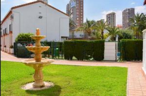 a yellow fountain in the middle of a grass field at RINCONADA REAL BUNGALOW-PLAYA LEVANTE in Benidorm