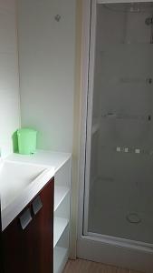 uma casa de banho com um chuveiro e um lavatório branco em mobil home em Lacanau-Océan