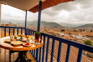 einen Tisch mit Teller mit Speisen auf dem Balkon in der Unterkunft Auka Boutique San Blas in Cusco