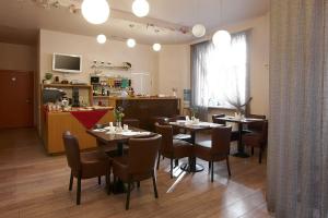 a restaurant with tables and chairs in a room at Hotel Edvards in Rīga