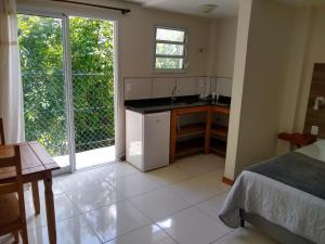 cocina con cama y lavabo en una habitación en Casa Figueira na Pedra, en Florianópolis