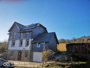 una casa azul con techo de gambrel en Luxuriöse Ferienwohnung im Herzen des Sauerlandes, en Meschede