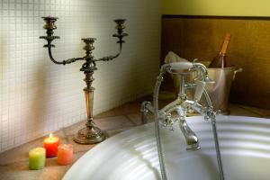 ein Badezimmer mit einer Badewanne, Kerzen und einem Waschbecken in der Unterkunft Podere San Raffaele in Aiello del Sabato