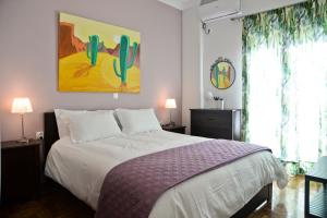 een slaapkamer met een bed met een cactusschilderij aan de muur bij Meros - Athenian Residencies in Athene