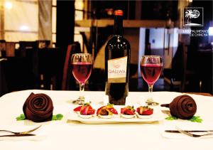 a bottle of wine and two glasses of red wine at Qallwa Chincha in Chincha Alta