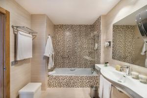 a bathroom with a tub and a sink at Royal Palm Resort & Spa - Adults Only in Playa Jandia