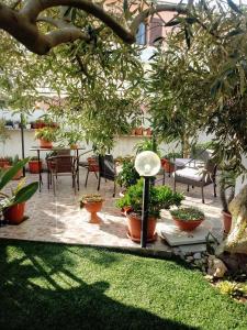 a patio area with chairs, tables, and plants at S'incantu in Olbia