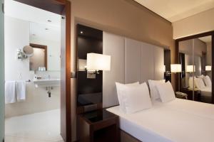 um quarto de hotel com uma cama e um lavatório em TURIM Restauradores Hotel em Lisboa