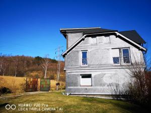 a gray house with a black roof on a yard at Luxuriöse Ferienwohnung im Herzen des Sauerlandes in Meschede