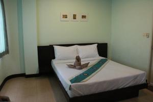 Baan Vor. Sumongkol Service Apartment في كون كاين: غرفة نوم مع سرير وشمعة عليه