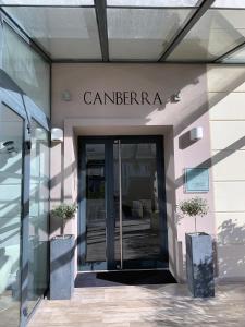 - une entrée pour un bâtiment avec une porte en verre dans l'établissement Hôtel Le Canberra, à Cannes