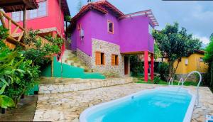 a house with a swimming pool in front of it at Pousada Pináles in Visconde De Maua