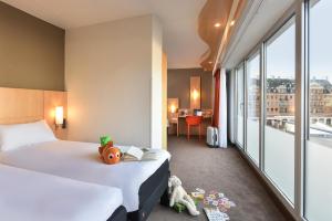 a hotel room with two beds and a large window at ibis Kortrijk Centrum in Kortrijk +107 photos