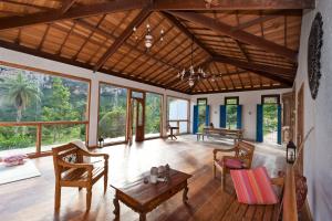 ein Wohnzimmer mit einem Tisch, Stühlen und Fenstern in der Unterkunft Altamira Eco Retreat in Altamira