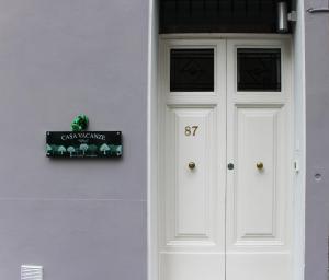 a white door of a house with a sign on it at I Pini house in the heart of the city in Pisa